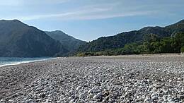 Drzno javno srečanje z oralnim seksom na plaži, kjer se vrhunec pogoltne