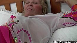 Isabel, a British woman with large breasts, masturbates her old clitoris.