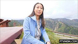 Busty Asian MILF flashing her big tits outdoors in public view.