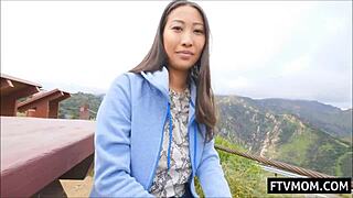 Busty Asian MILF flashing her big tits outdoors in public view.