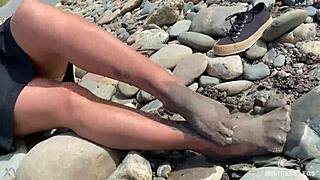 i show you my messy nylon feet close-ups in torn pantyhose on the river bank.