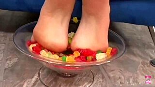 a kinky brunette sticks her feet in gummy bears and performs a footjob until cumshot
