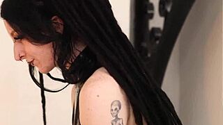 British goth teases in latex and fishnets in bedroom.