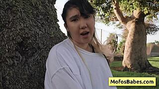 this sexy asian teen is revealing her big natural boobs to her friend outdoors.