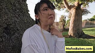 this sexy asian teen is revealing her big natural boobs to her friend outdoors.