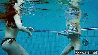 Russian girls in bikinis swimming and playing underwater in the pool