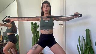 Inked girl does rubber band workout warm-up for strength and yoga fitness