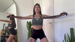 Inked girl does rubber band workout warm-up for strength and yoga fitness