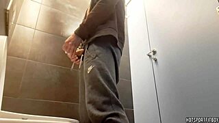 Sexy guy masturbating his monster cock in a public bathroom riskily
