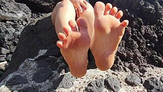 Seductive stepmom indulges in foot fetish on public beach. 😏