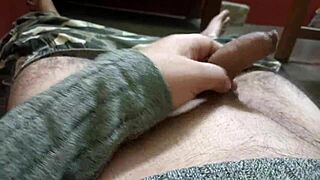 mature man grips and strokes his penis with rapid intense motions building to climax