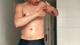 check out this sexy guy in black beach shorts hitting the bathroom for a close shave routine