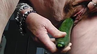oma neukt harige kut met komkommer in kitchen